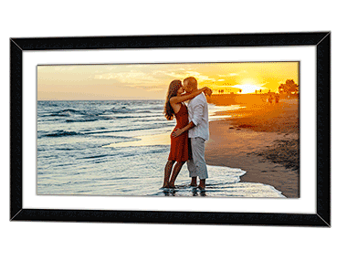 Panoramic framed poster of a honeymoon couple kissing on a beach in the sunset