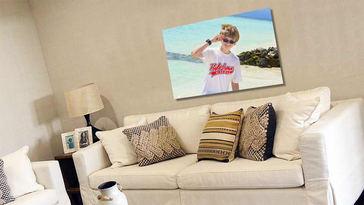 A2 poster of a child sitting on the grass reading a storybook, hanging on the wall behind a sofa